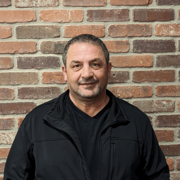 a man standing in front of a brick building