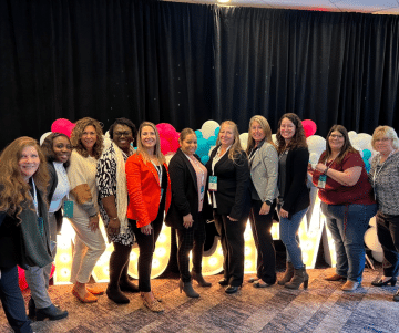 a group of people standing in front of a crowd posing for the camera