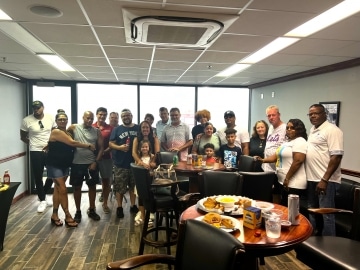 a group of people standing around a table