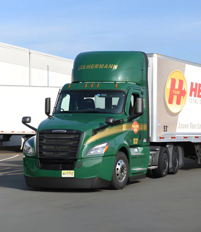 a large green truck is driving down the road