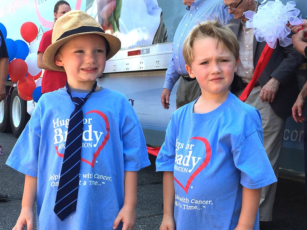 a young boy standing next to a child in a blue shirt