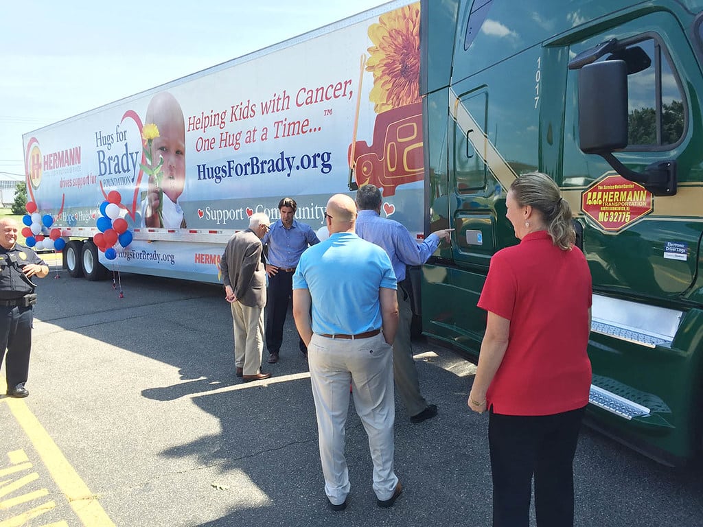 a group of people standing in front of a truck