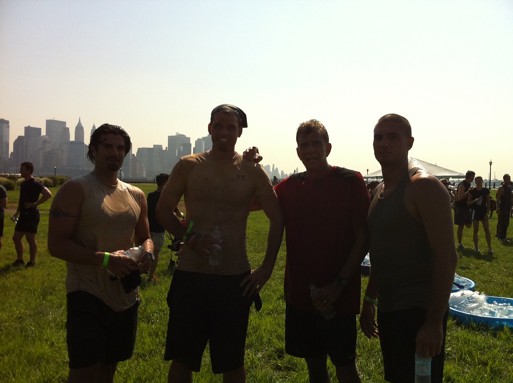 a group of people standing in a grassy area posing for the camera