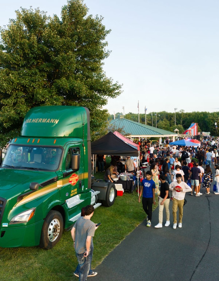 a group of people standing in front of a green truck