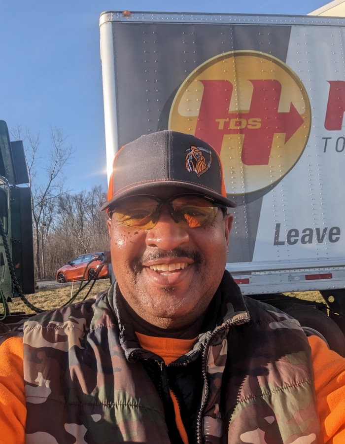 a man wearing a hat and smiling at the camera