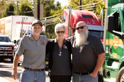 a group of people standing in front of a car posing for the camera