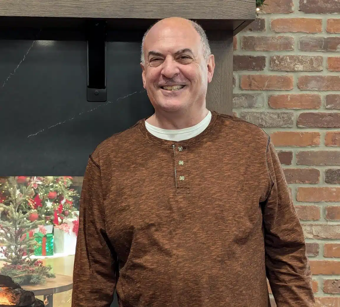 Male standing in front of a brick wall