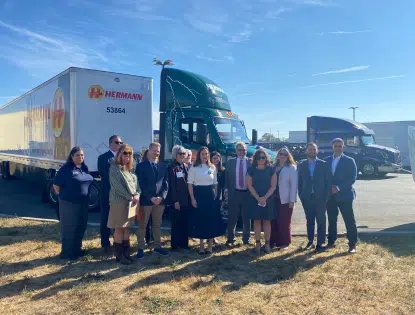 Group of people standing in front of an electric truck