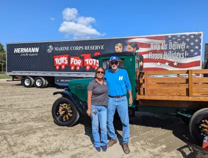 Two people standing in front of a trailer